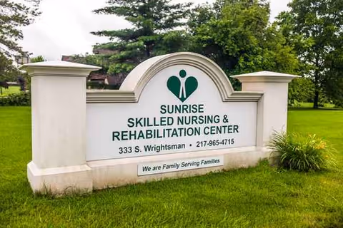 A large Sunrise Skilled Nursing & Rehabilitation Center sign on a grassy, landscaped lawn.