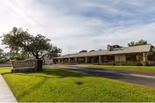 Exterior view of Anaheim Crest Nursing Center, a single-story building with a sign and lawn.