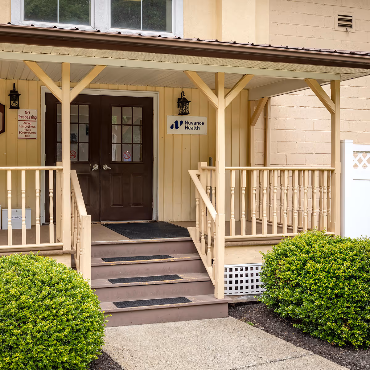 Front entrance of Nuvance Health clinic with brown doors and beige porch