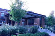Exterior view of Centre Crest senior living facility with steps, ramp, and landscaped greenery.