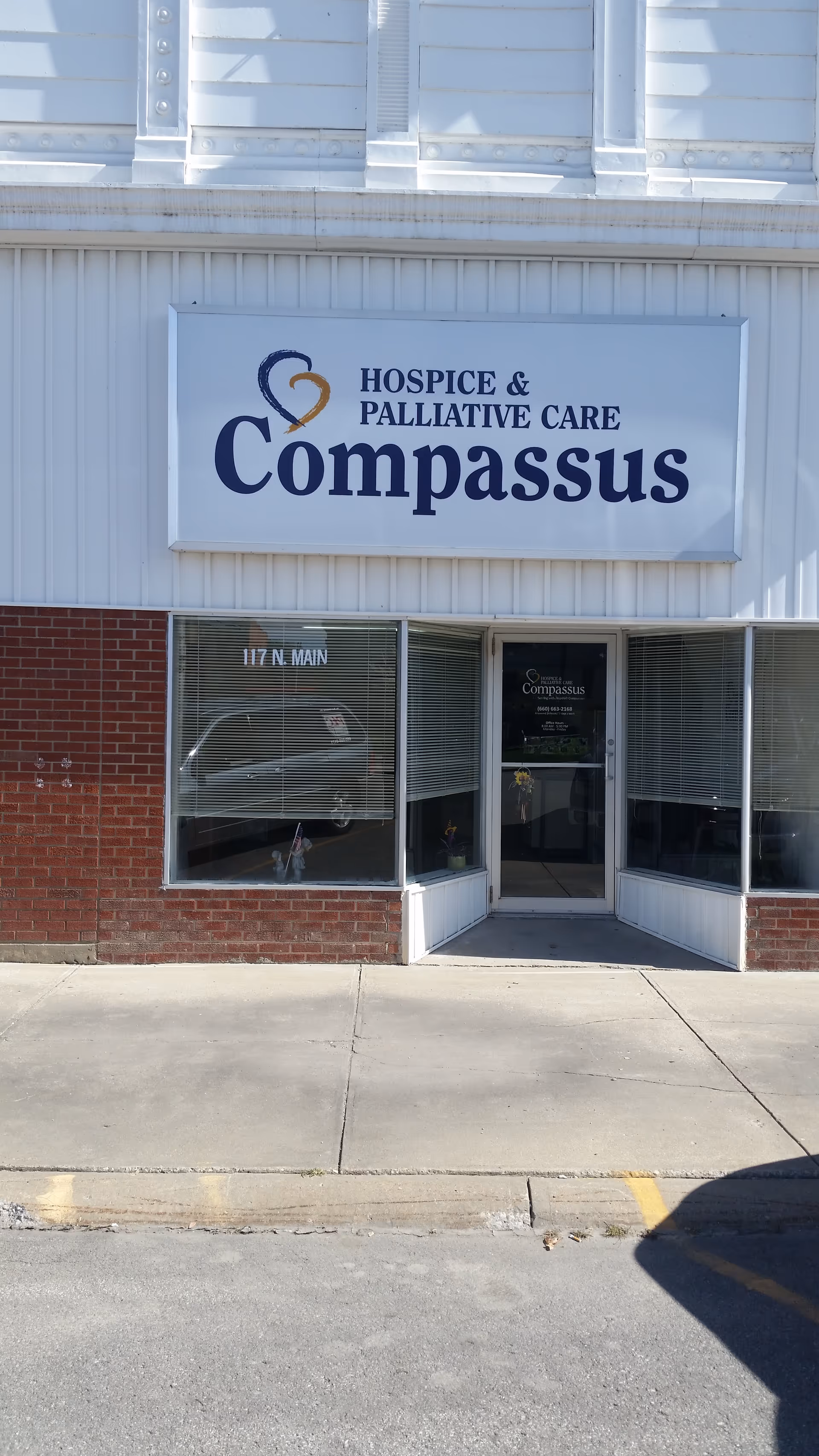 Front exterior of a Compassus Hospice and Palliative Care building with a sign.