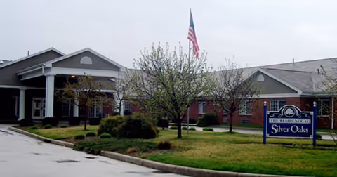 Front view of Silver Oaks Health Campus exterior with flag, sign, and landscaped lawn.