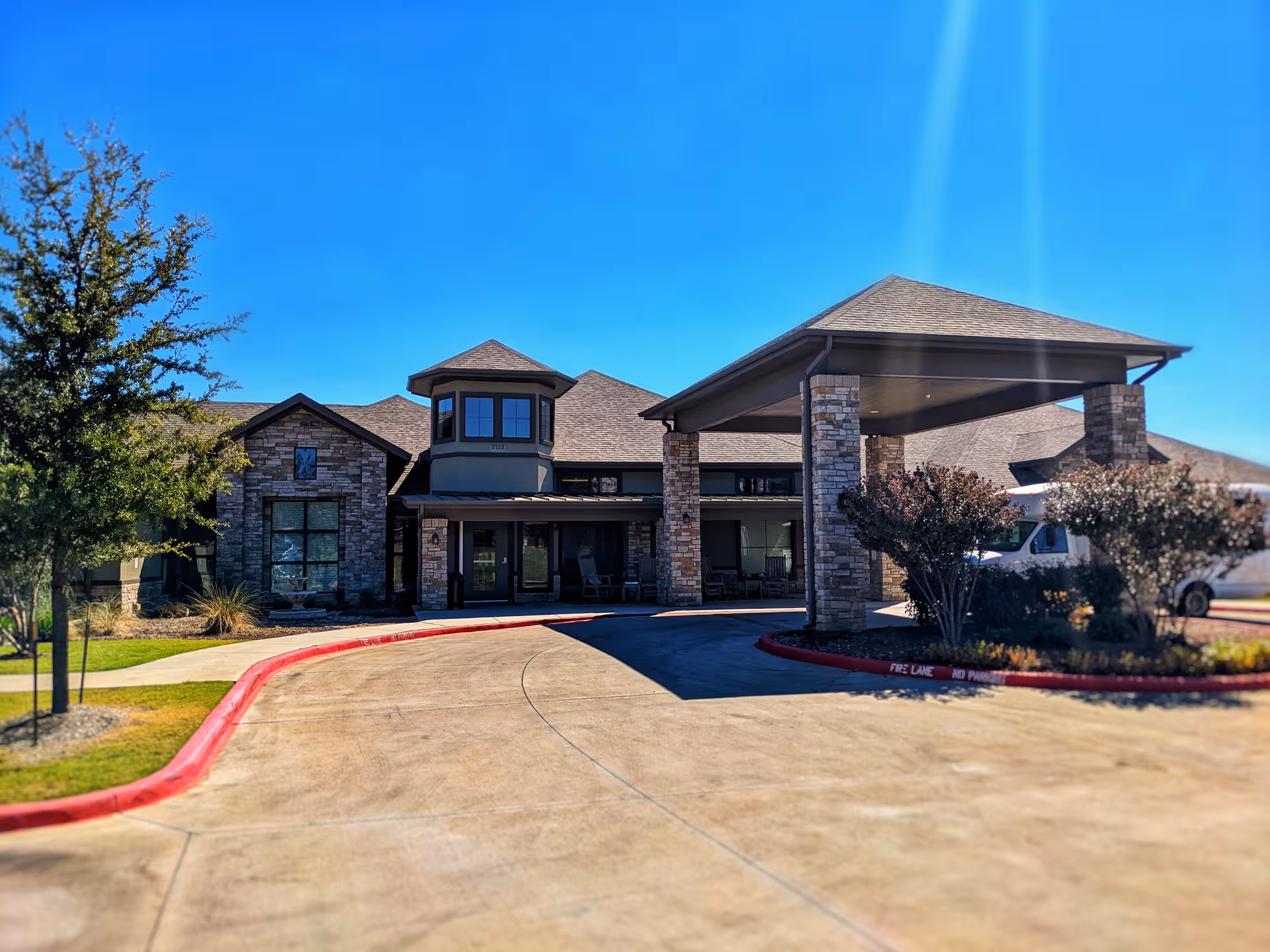 Exterior view of Forum Parkway Health and Rehabilitation facility with stone facade and covered entrance.