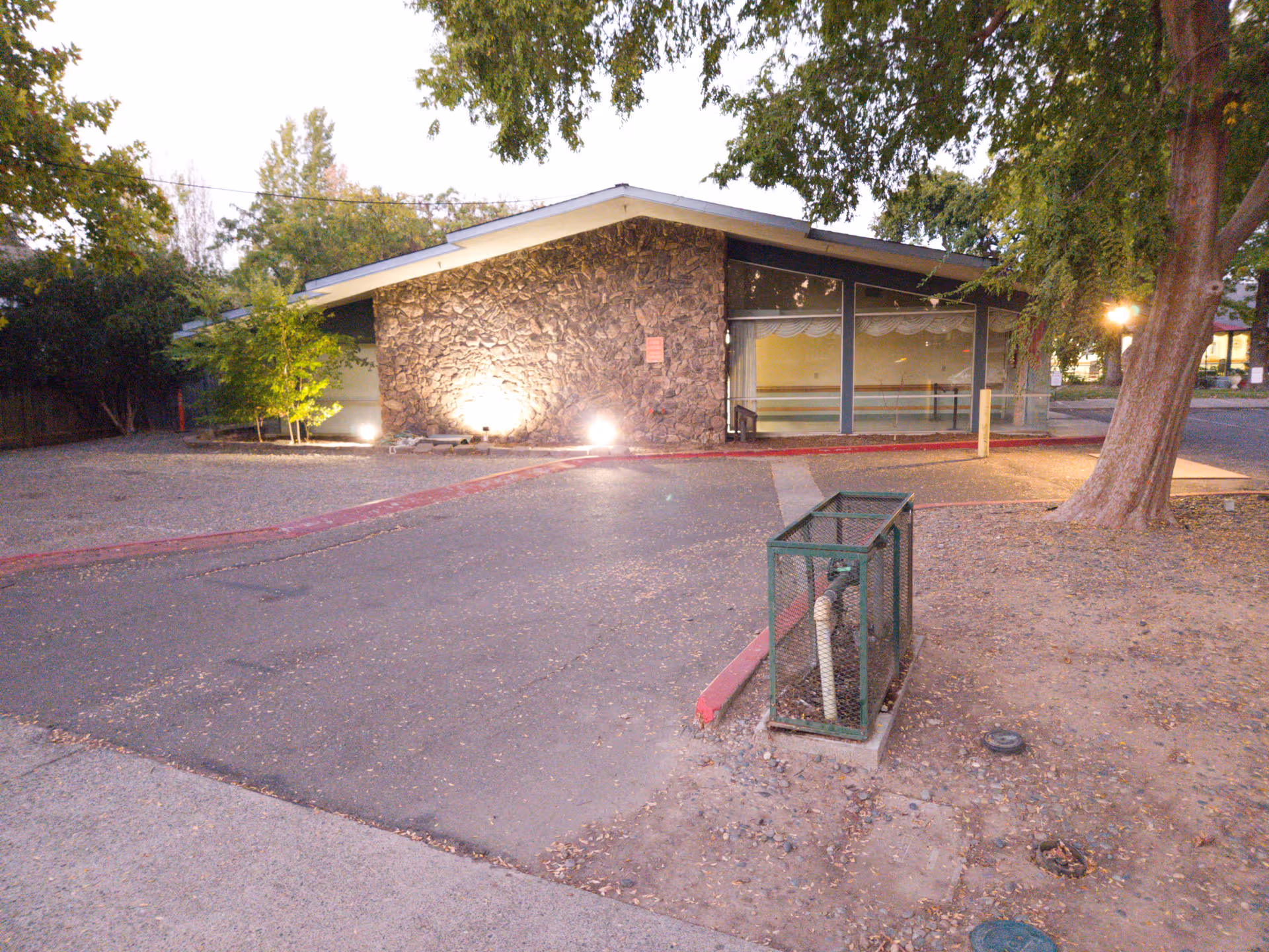 Front view of College Oak Nursing and Rehab building with stone wall and large windows.