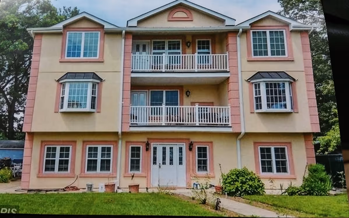 Three-story Elyon Assisted Living building with balconies, large windows, and a central entrance.