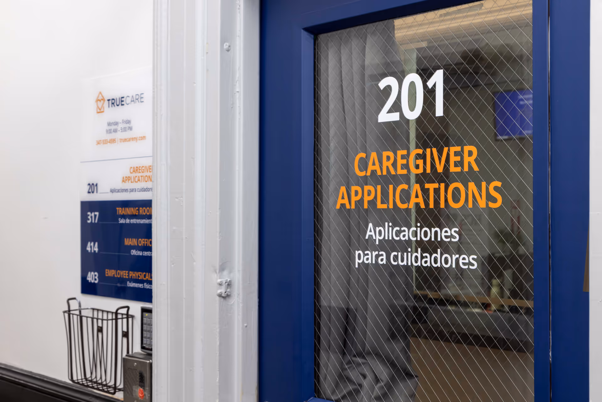 Blue door displays caregiver applications with a wall directory and True Care branding nearby.