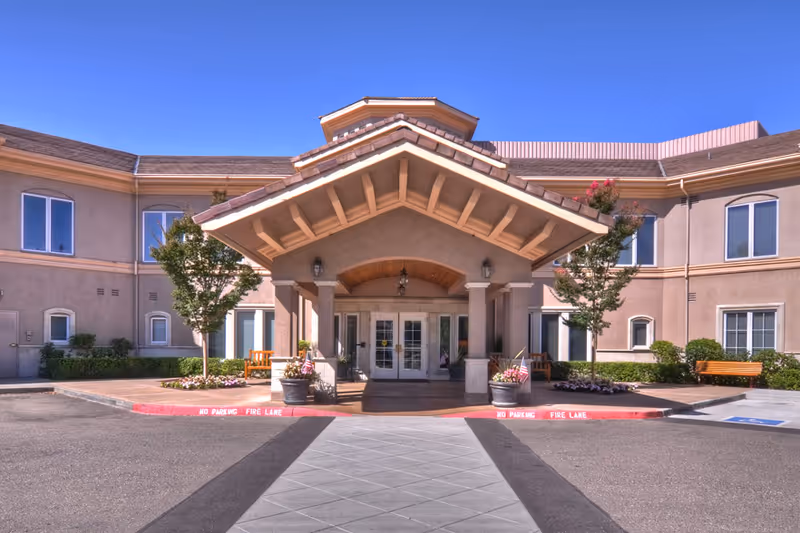 Exterior view of Ivy Park at Santa Rosa entrance with a covered front portico and benches.