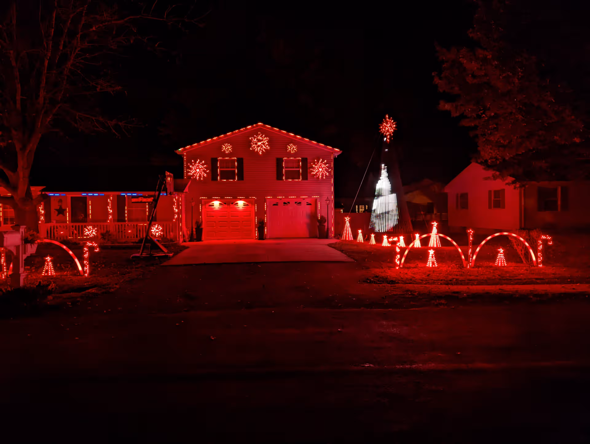 Front view of a house decorated with red holiday lights at night