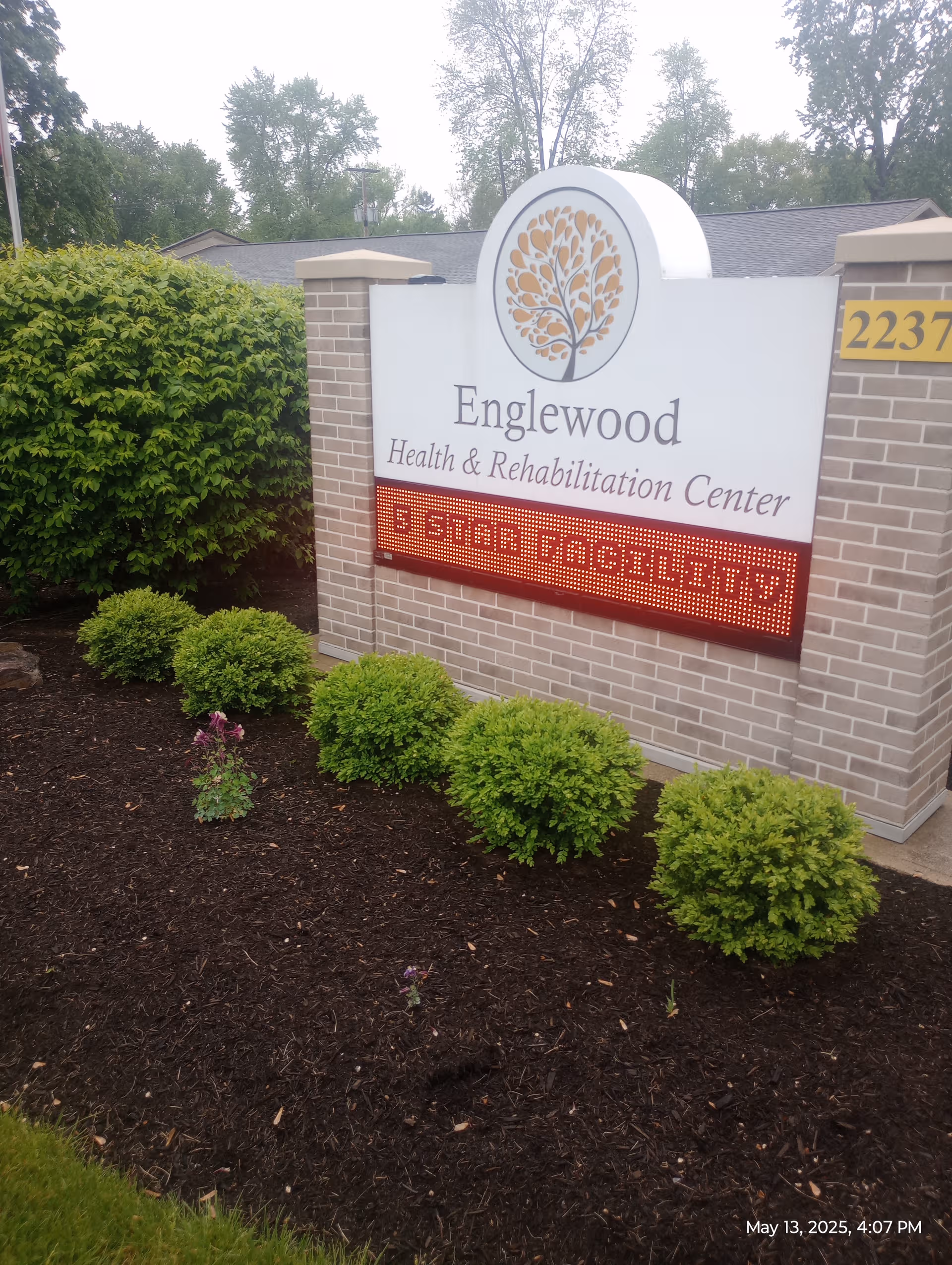 Exterior Englewood Health and Rehabilitation Center sign with brick pillars and landscaping.