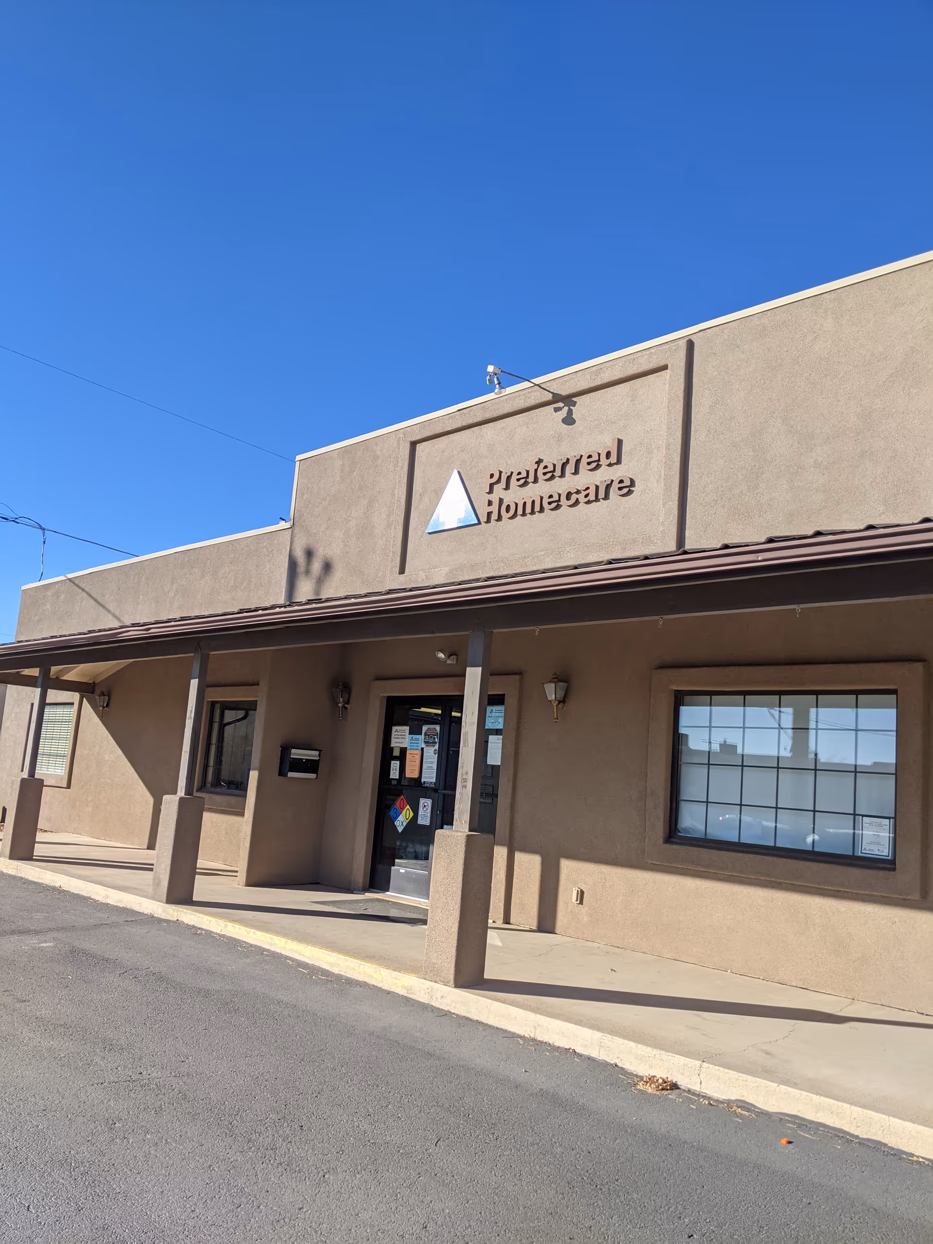 Exterior view of a beige building with a 'Preferred Homecare' sign at the entrance.