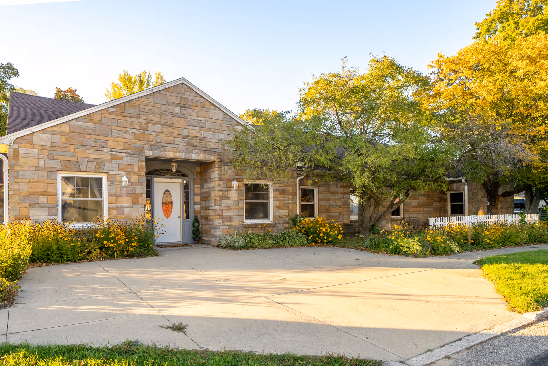 Front view of a single-story stone building with a landscaped entrance.