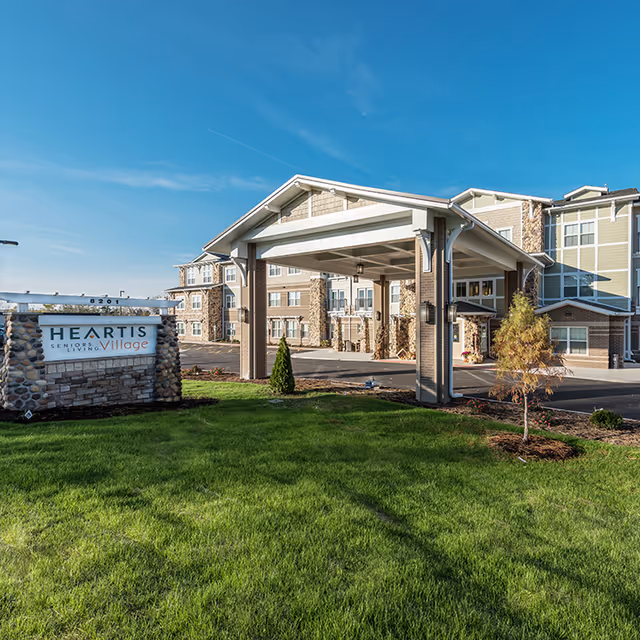 Exterior view of Heartis Peoria senior living building with a covered front entrance.