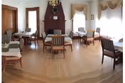 A bright living room in Studley Home with chairs, tables, and a fireplace.