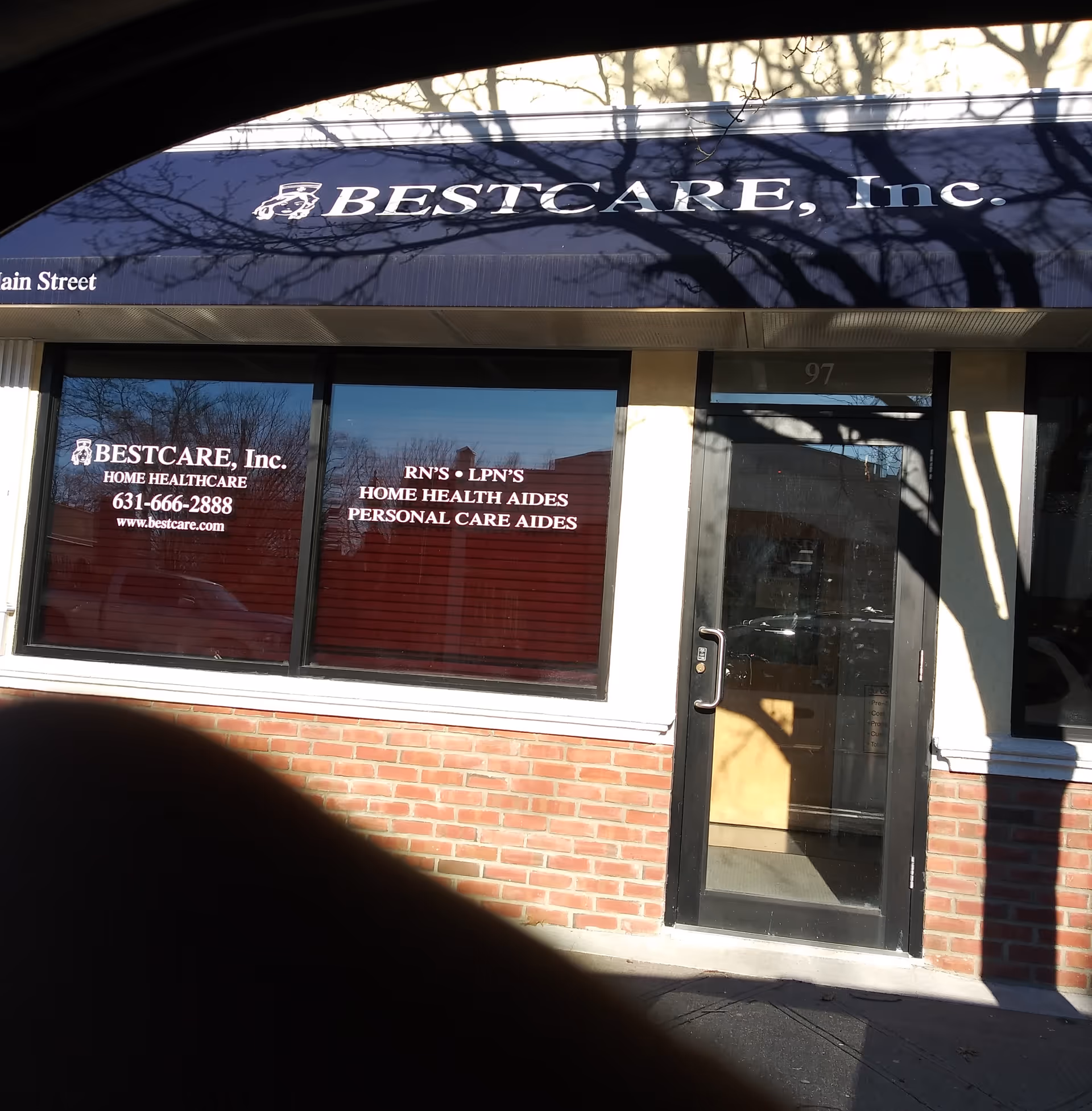 Exterior storefront with BestCare, Inc. signage under a blue awning, brick facade.