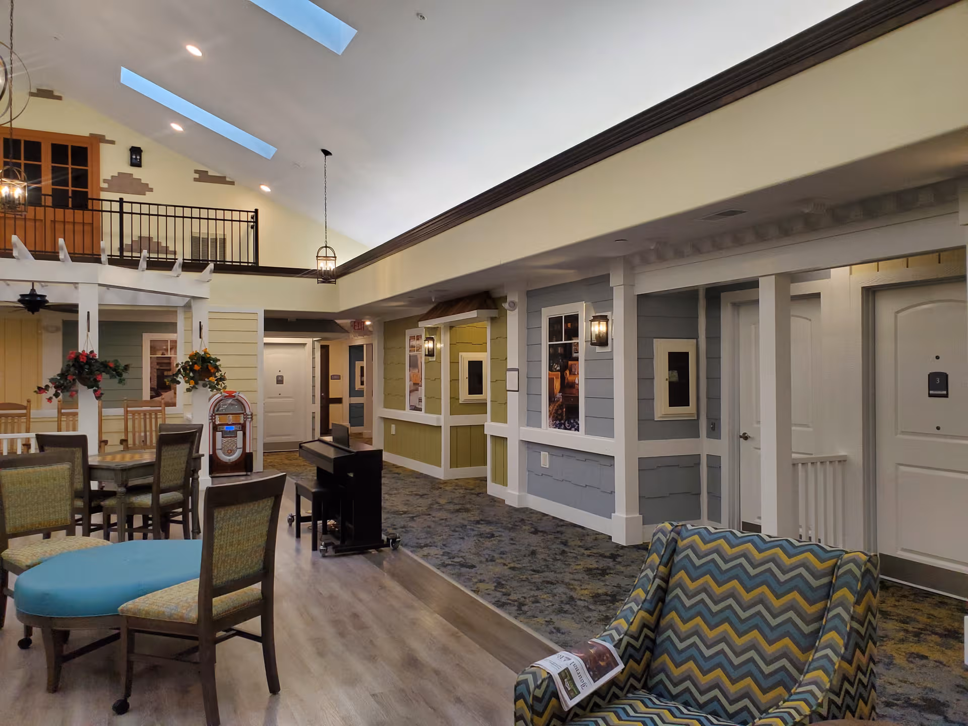 Spacious senior living common area with seating, decor, and a piano.
