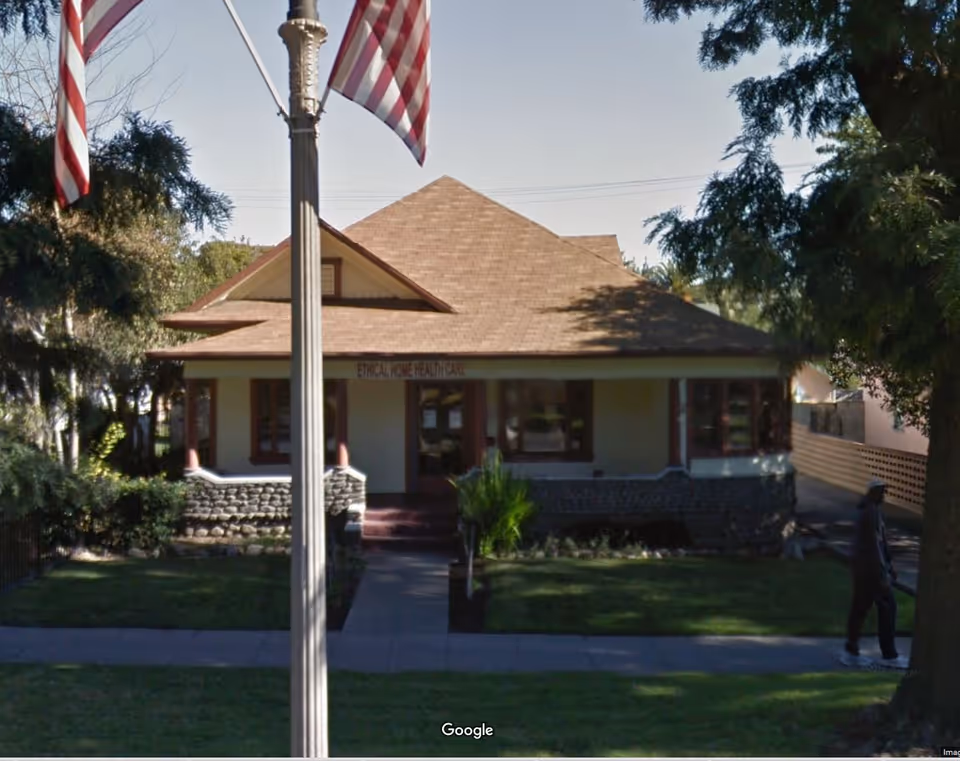 Front view of Ethical Home Health Care building with flags and a walkway