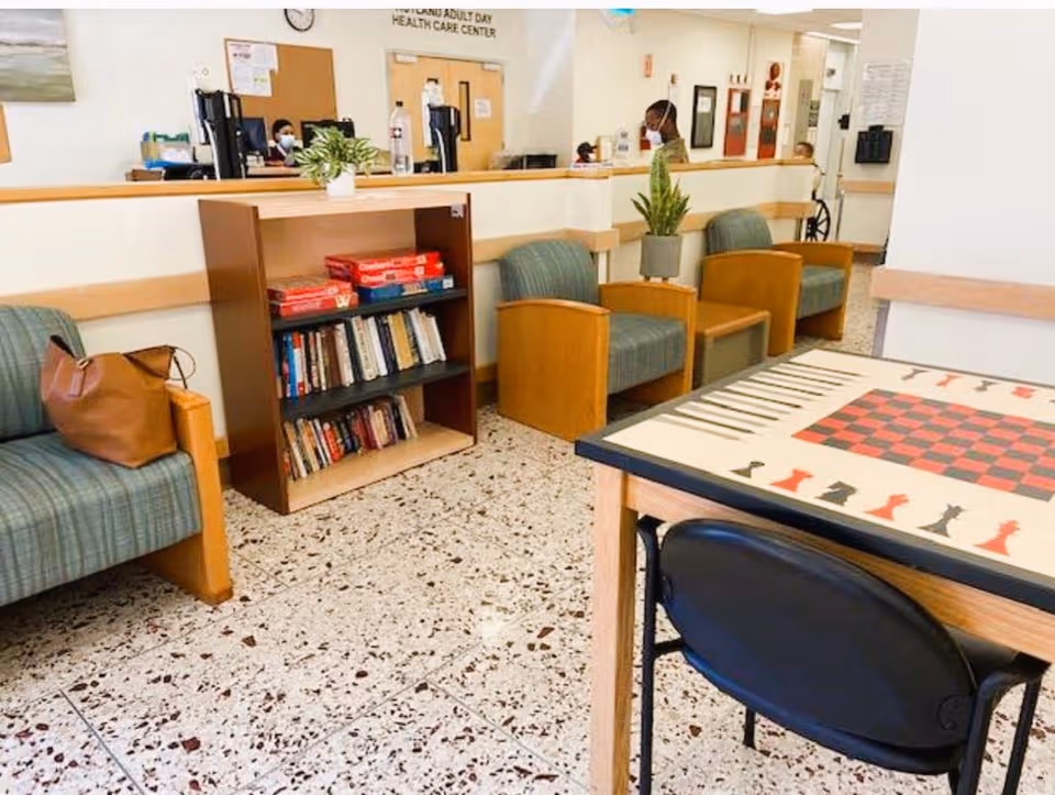 Interior waiting area at Rutland Nursing Home with chairs, a bookshelf, and a checkers table.