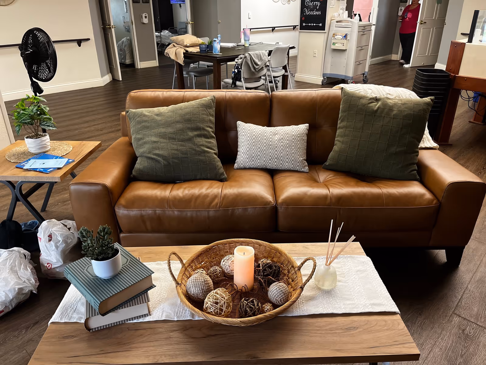 Cozy lounge area featuring a brown leather sofa, decorative pillows, and a wooden coffee table.