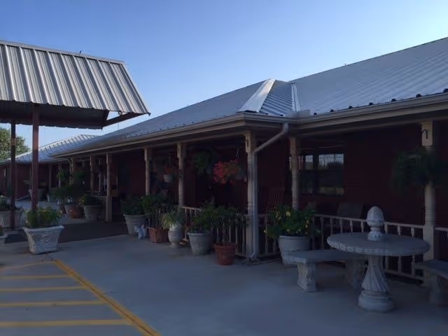 Exterior view of Redstone Park facility with a covered walkway and potted plants.