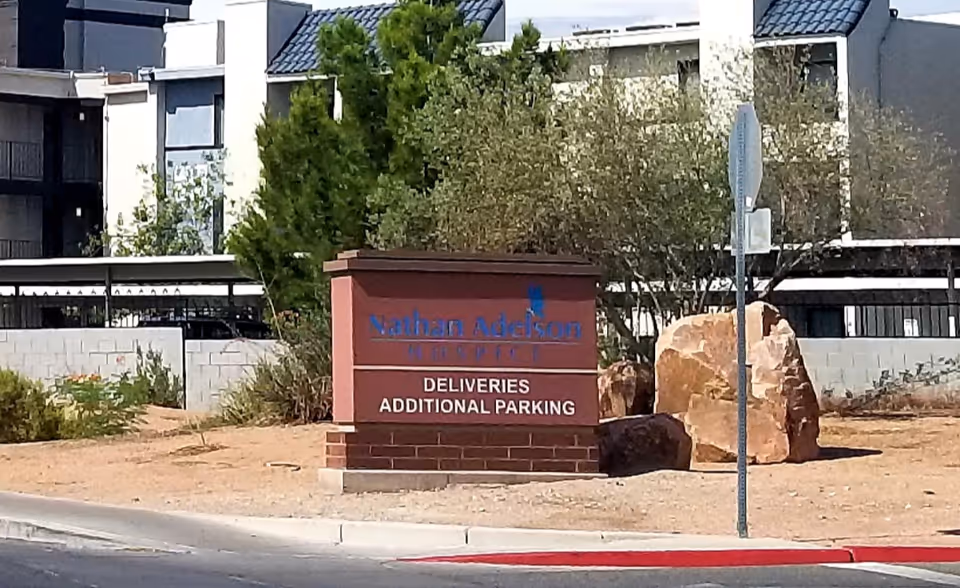 Exterior view of Nathan Adelson Hospice with a front sign and landscaping.