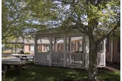 Front view of Elkins Rehabilitation & Care Center with a covered porch and trees.