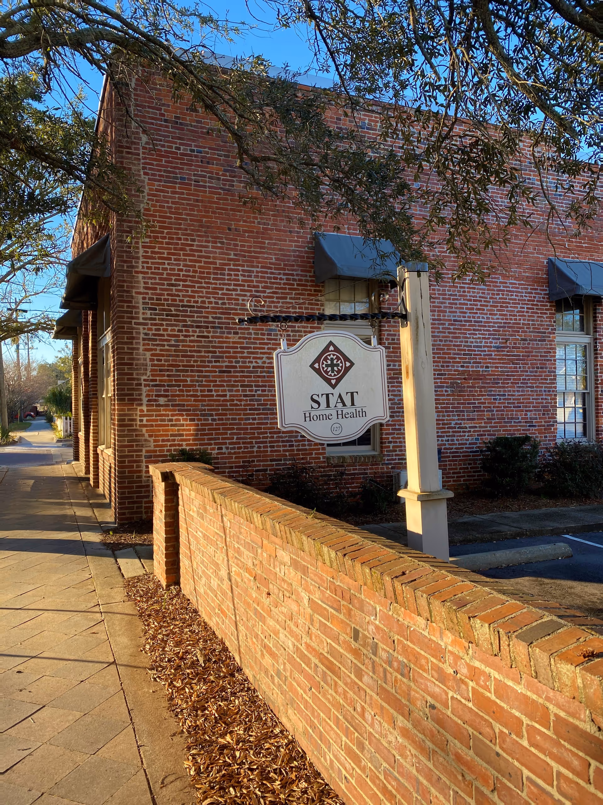The brick building exterior shows a STAT Home Health sign beside the sidewalk.