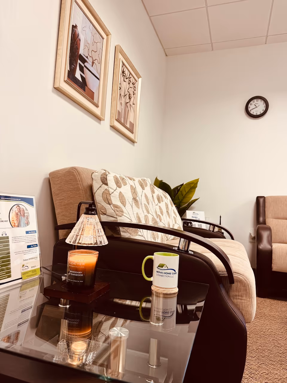 Cozy waiting area with sofa, glass coffee table, mug, and wall art.