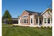 Front exterior of Hoosier Village senior living facility with manicured lawn.