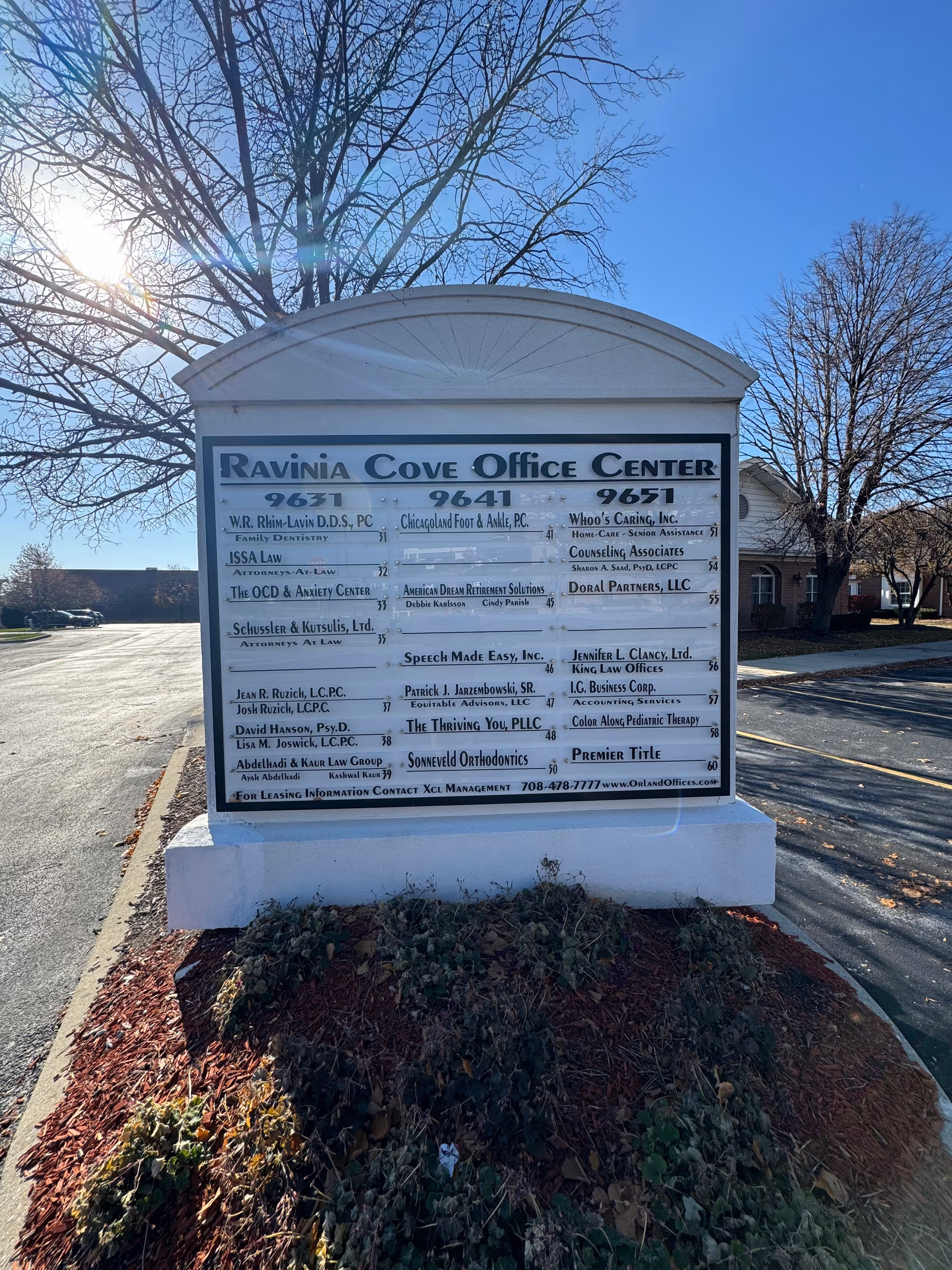 A large outdoor signboard listing tenants at Ravinia Cove Office Center.