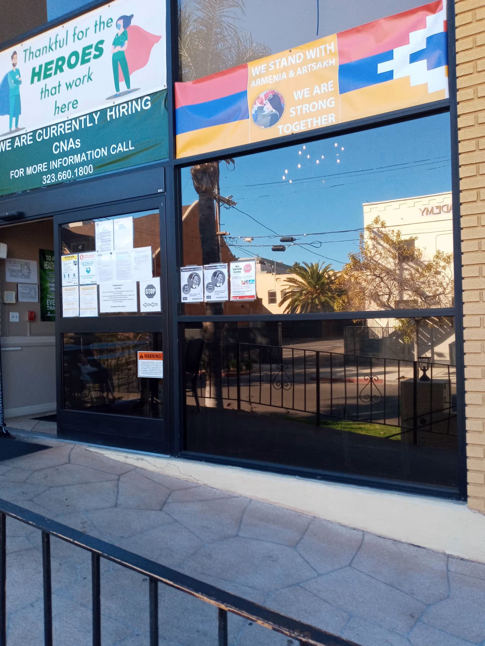 Exterior view of Alexandria Care Center with large glass windows and banners.