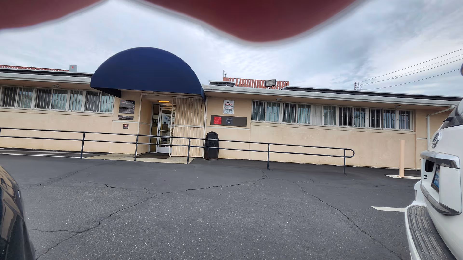 Exterior view of Windsor Hampton Care Center with a blue curved canopy over the entrance.