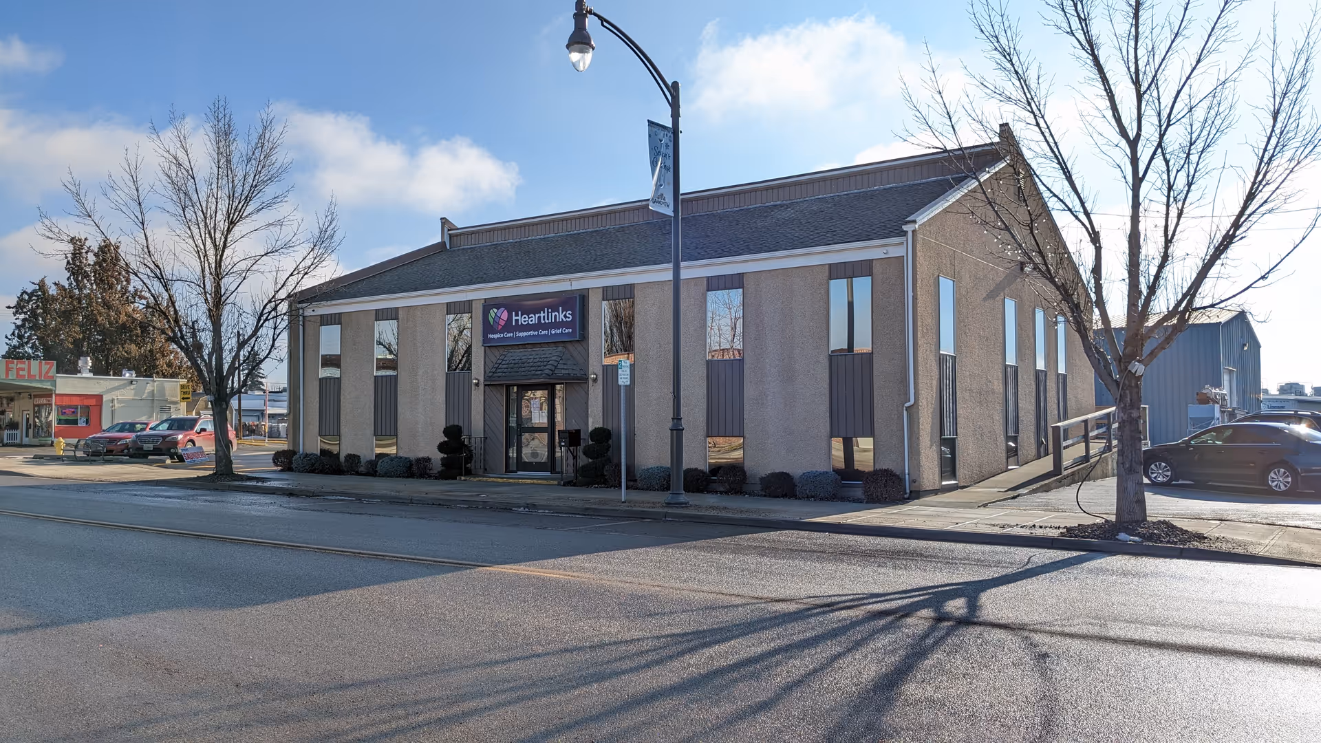 Exterior view of Heartlinks senior living facility with sign, street, and bare trees.