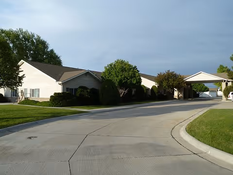 Exterior view of Highland Park Assisted Living showing a curved driveway and covered entrance.