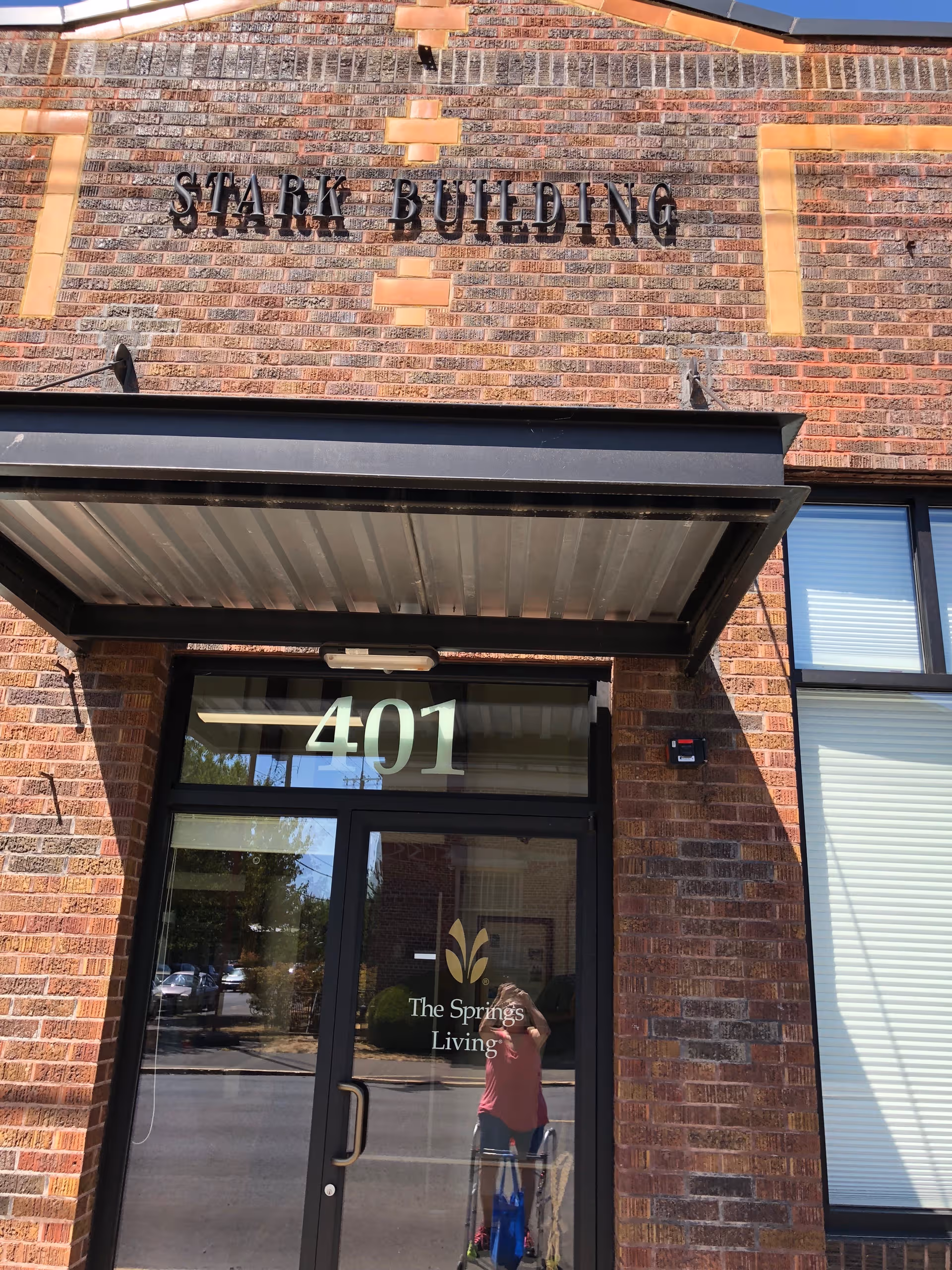 Brick building entrance with 'Stark Building' sign and door displaying 'The Springs Living' logo and 401.