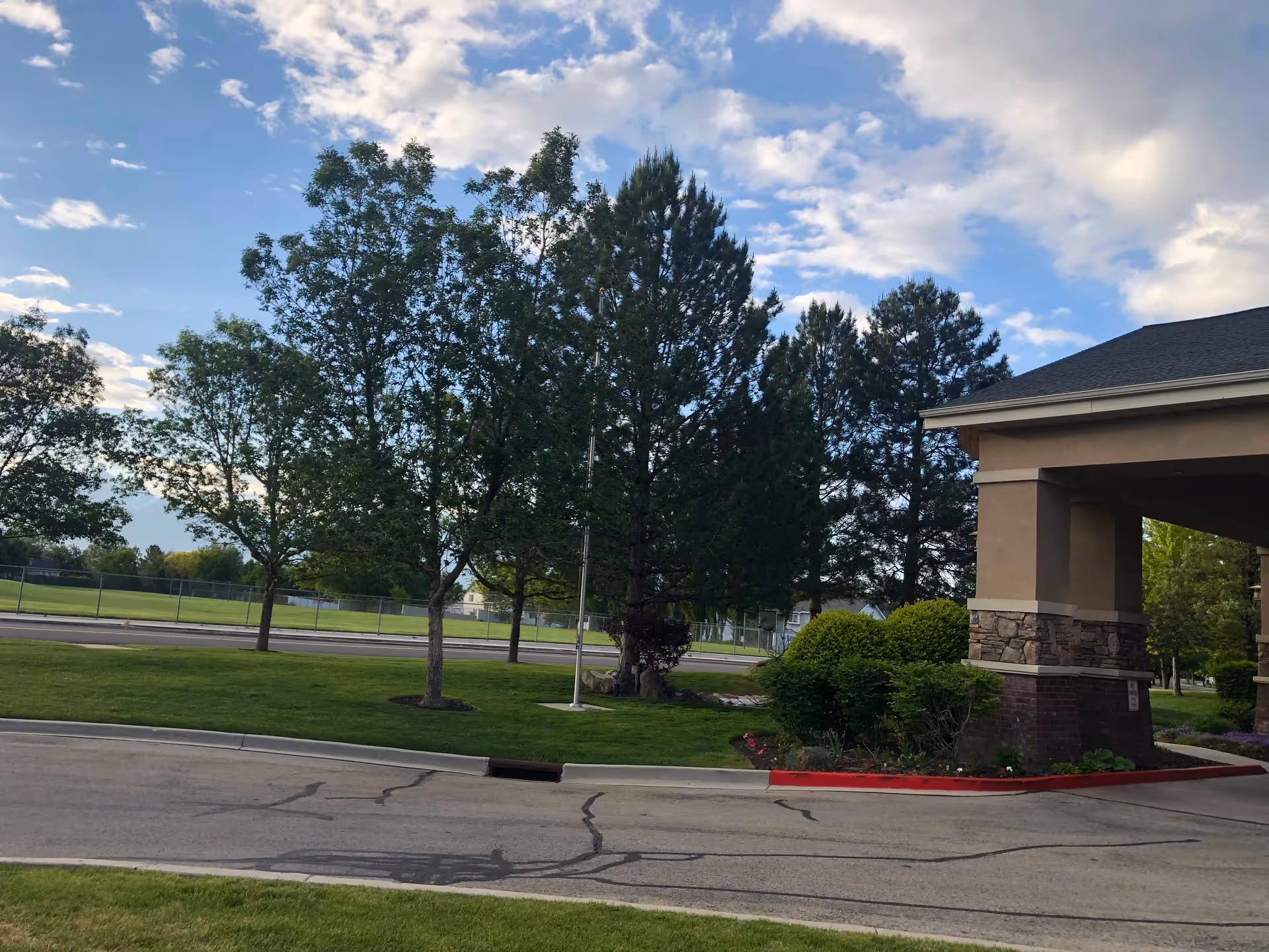 Exterior view of Legacy House of Taylorsville with trees, entrance, and parking.