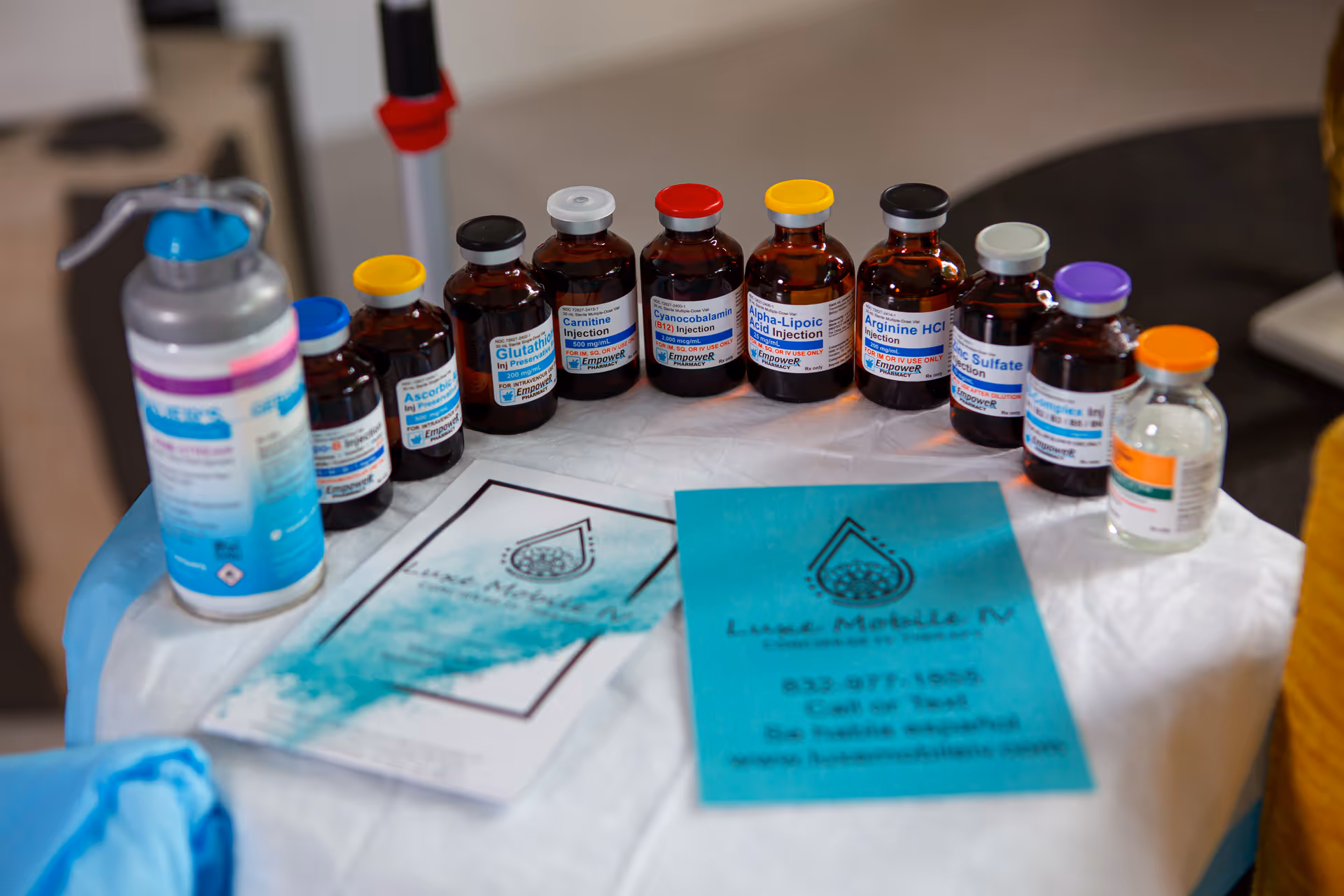A table holds medical vials and IV supplies branded Luxe Mobile IV Houston.