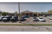 Front view of SunPorch of Dodge City with parked cars in the lot.