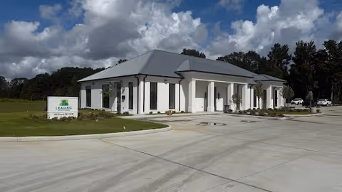 Front exterior of Leading Home Care Opelousas facility with white columns and a parking lot.