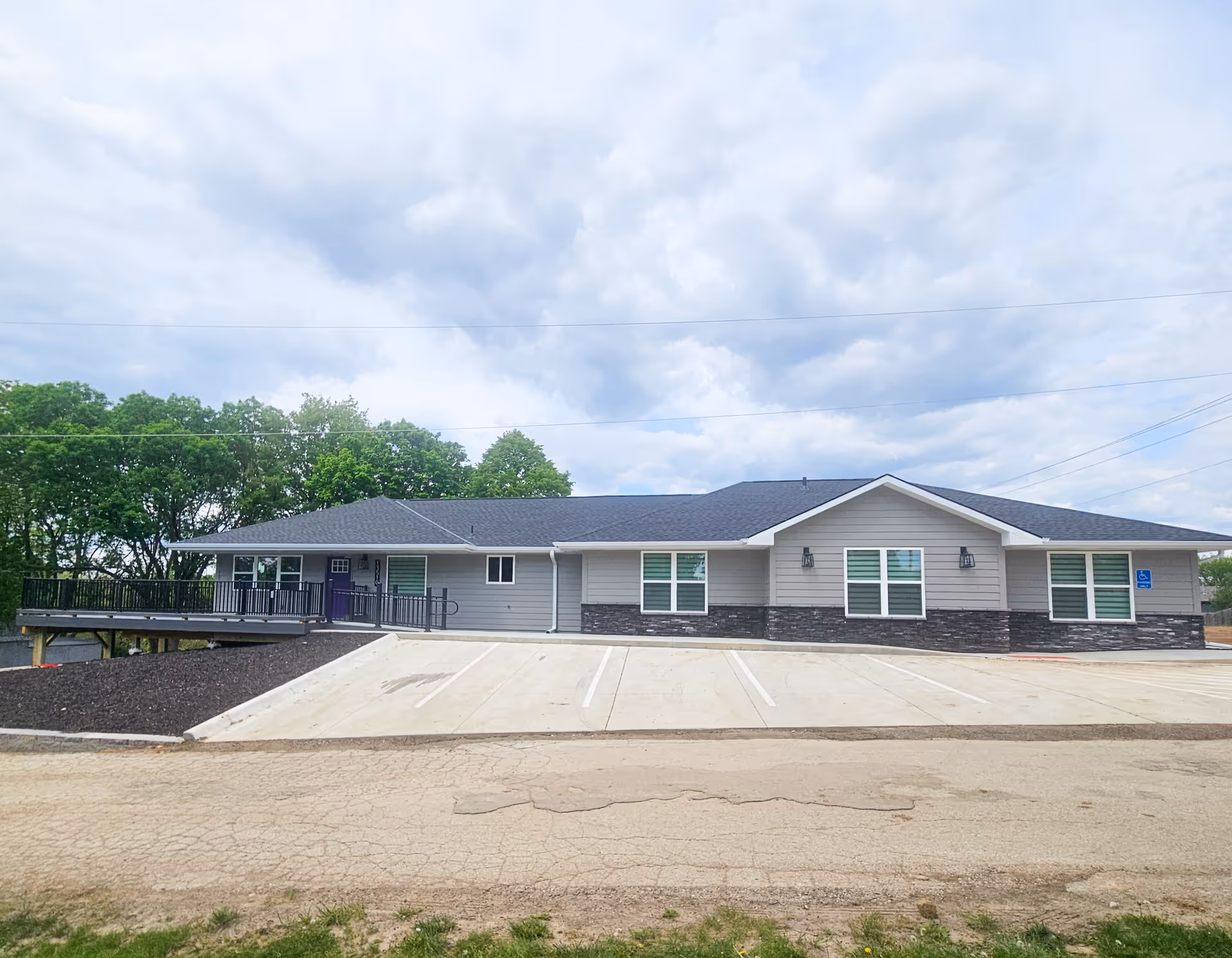 Front view of Legato Living at Heartland Hills, a single-story senior facility with gray siding.