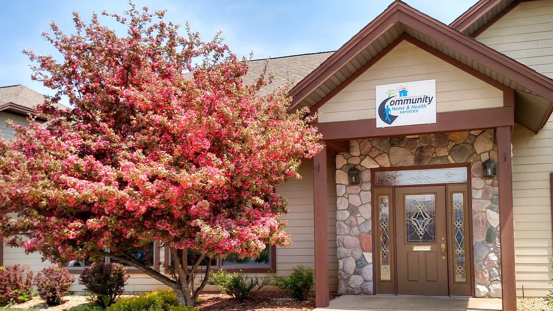Front entrance of Community Home and Health Services with a blooming pink tree.
