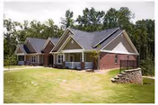 Single-story brick senior living facility with a manicured lawn and trees in front.