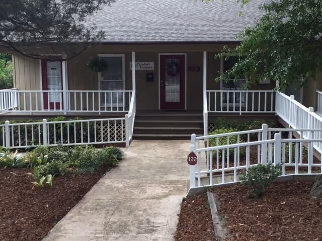 Front entrance of Comfort Keepers with white railings, walkway, and steps.