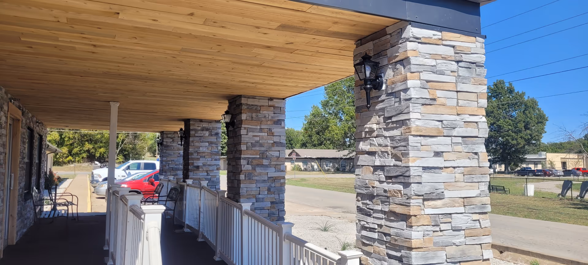 Covered walkway with stone columns and railing at Hays House exterior.