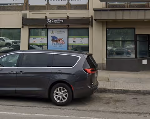 Exterior view of Patriot Home Care storefront with a parked gray minivan.