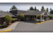 Exterior view of Hallmark Manor, a senior living facility with a curved driveway and entrance canopy.
