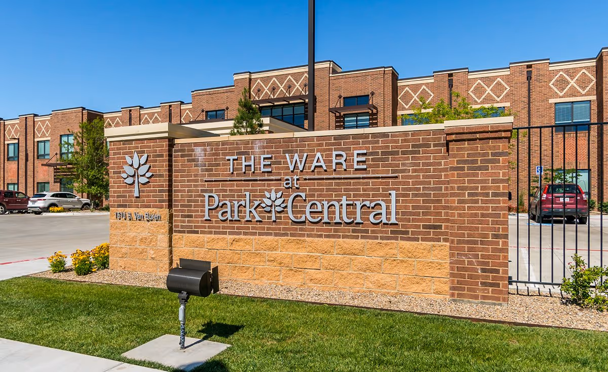 Brick building exterior with sign reading The Ware at Park Central in front
