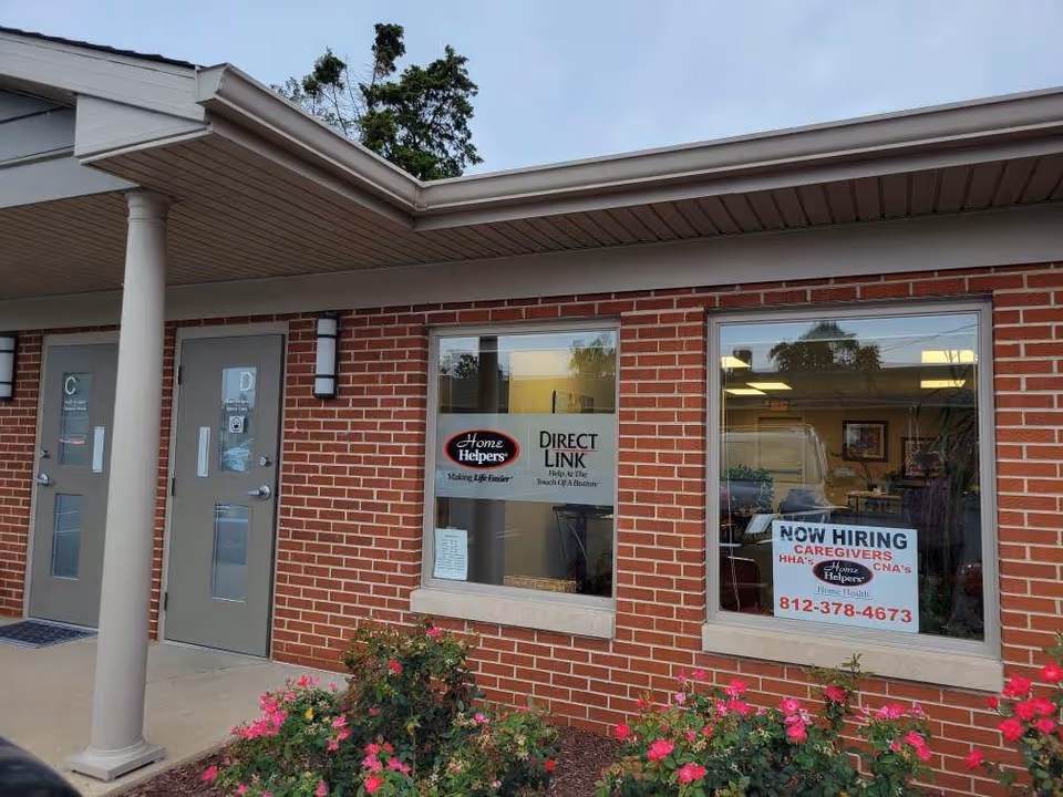 Brick facility exterior with two doors, windows, and signs.