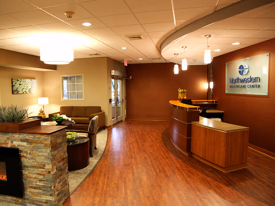 A polished lobby with a curved reception desk, seating area, and Northwestern Healthcare Center sign.