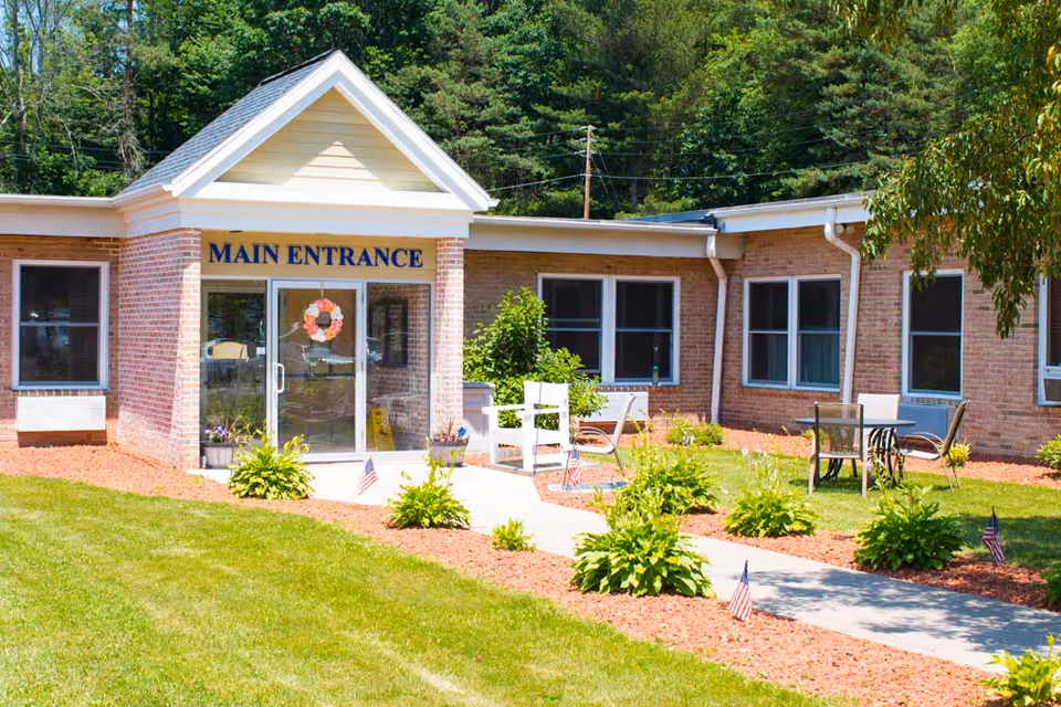 Brick facility with Main Entrance doors and outdoor seating.