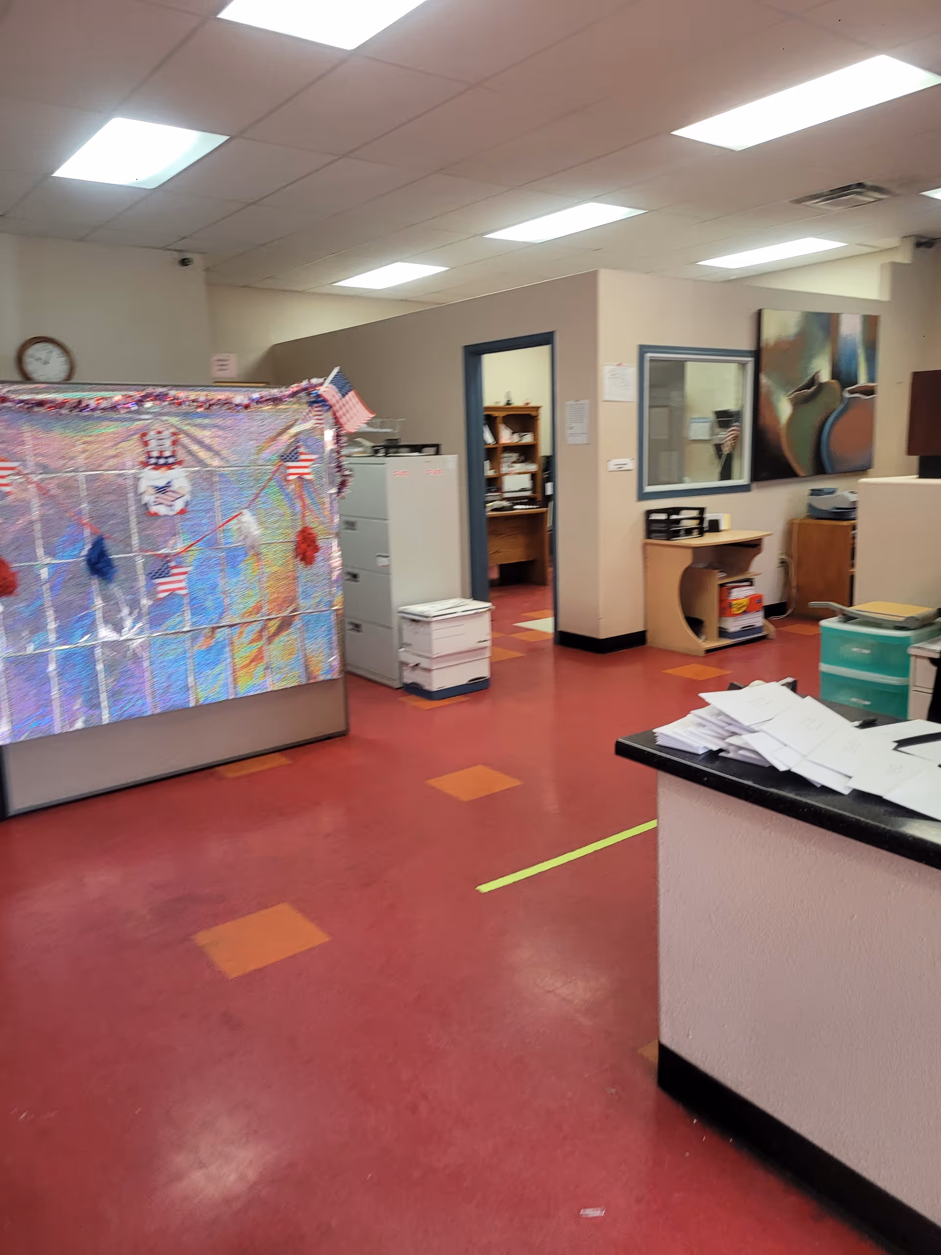 Interior of a senior living facility showing a reception desk and decorated partition.